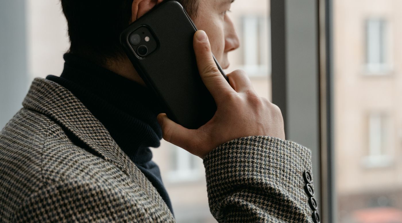 Un dirigeant au téléphone devant la fenêtre de son bureau